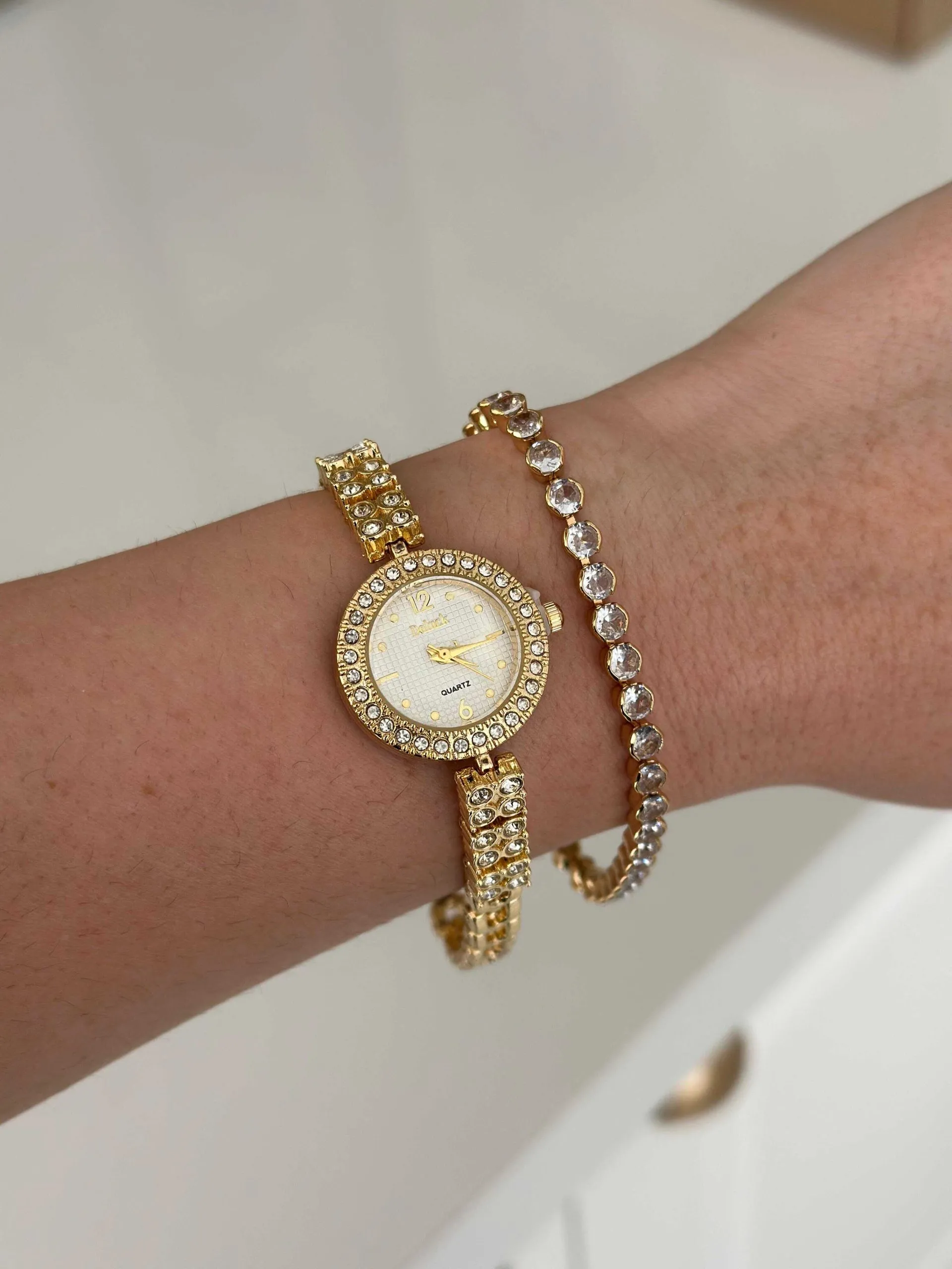 Relógio Dourado com Fundo Branco e Todo Cravejado