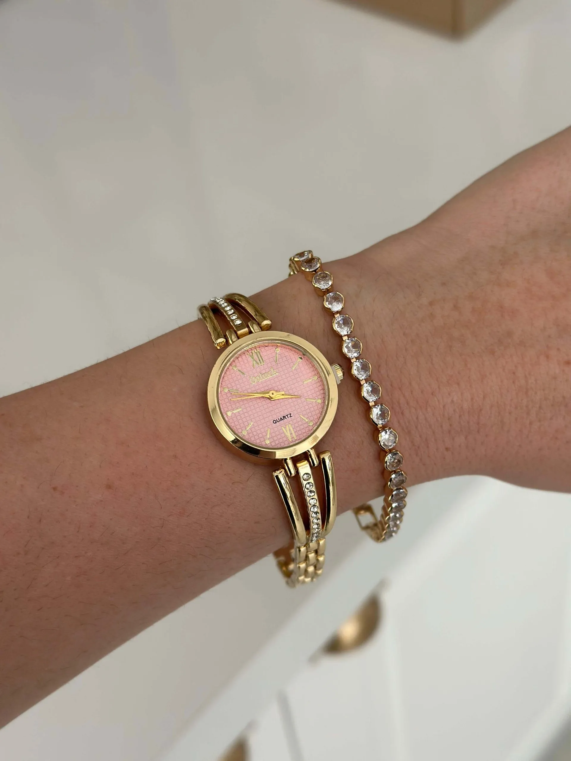 Relógio Dourado Fileira Cravejada com Fundo Rosa