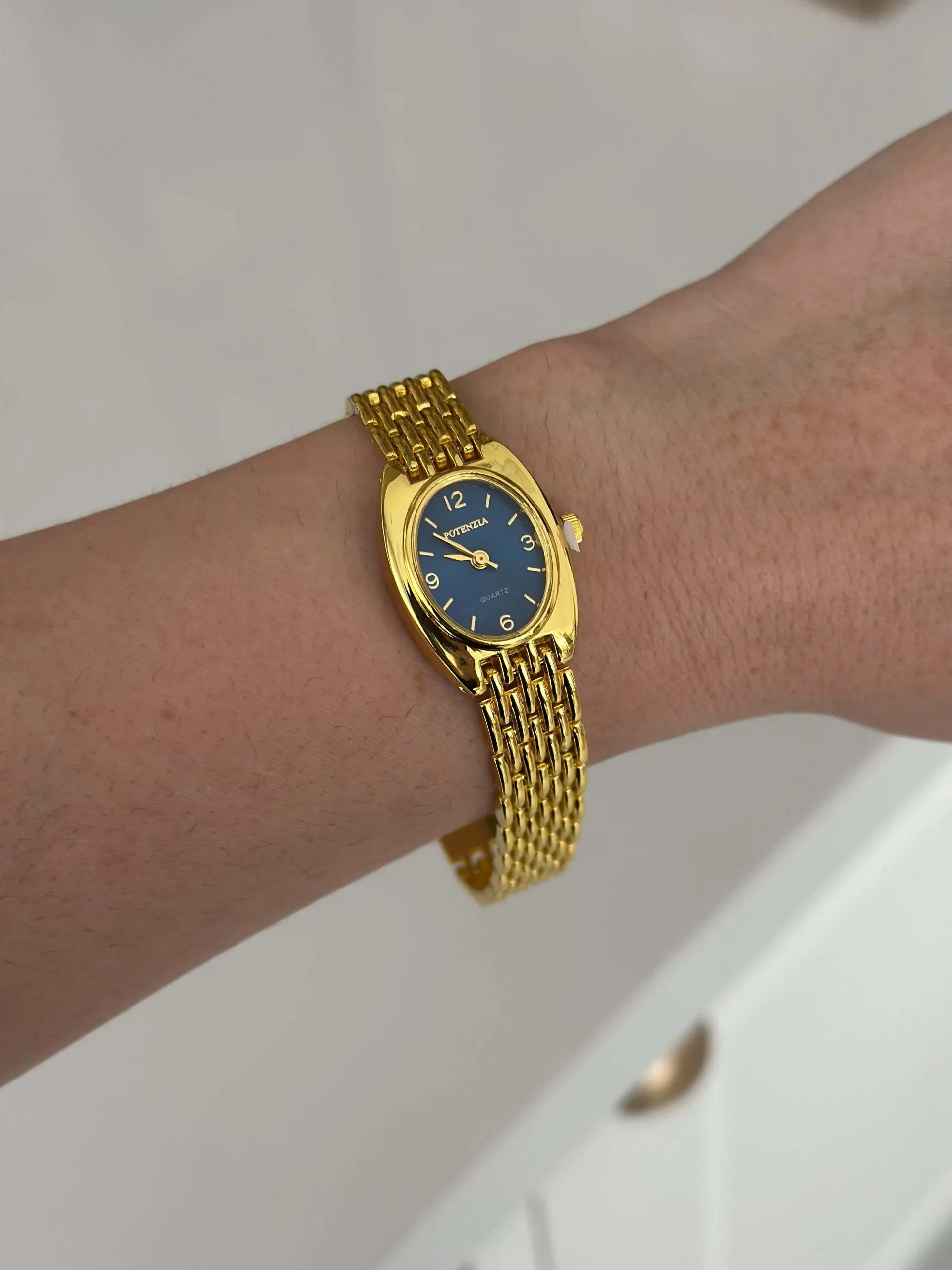 Relógio Dourado Oval Fundo Azul