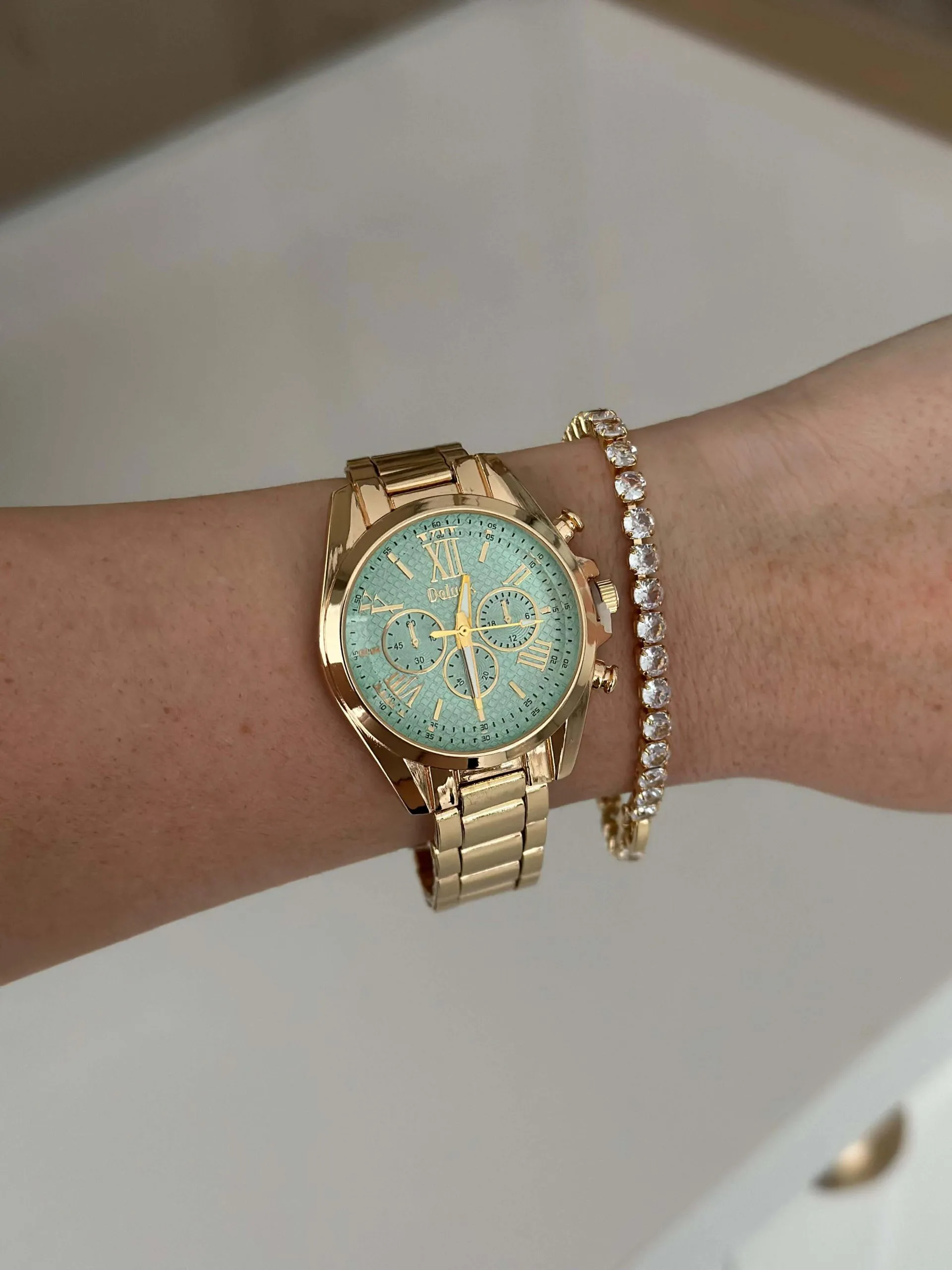 Relógio Dourado Redondo com Fundo Azul Claro