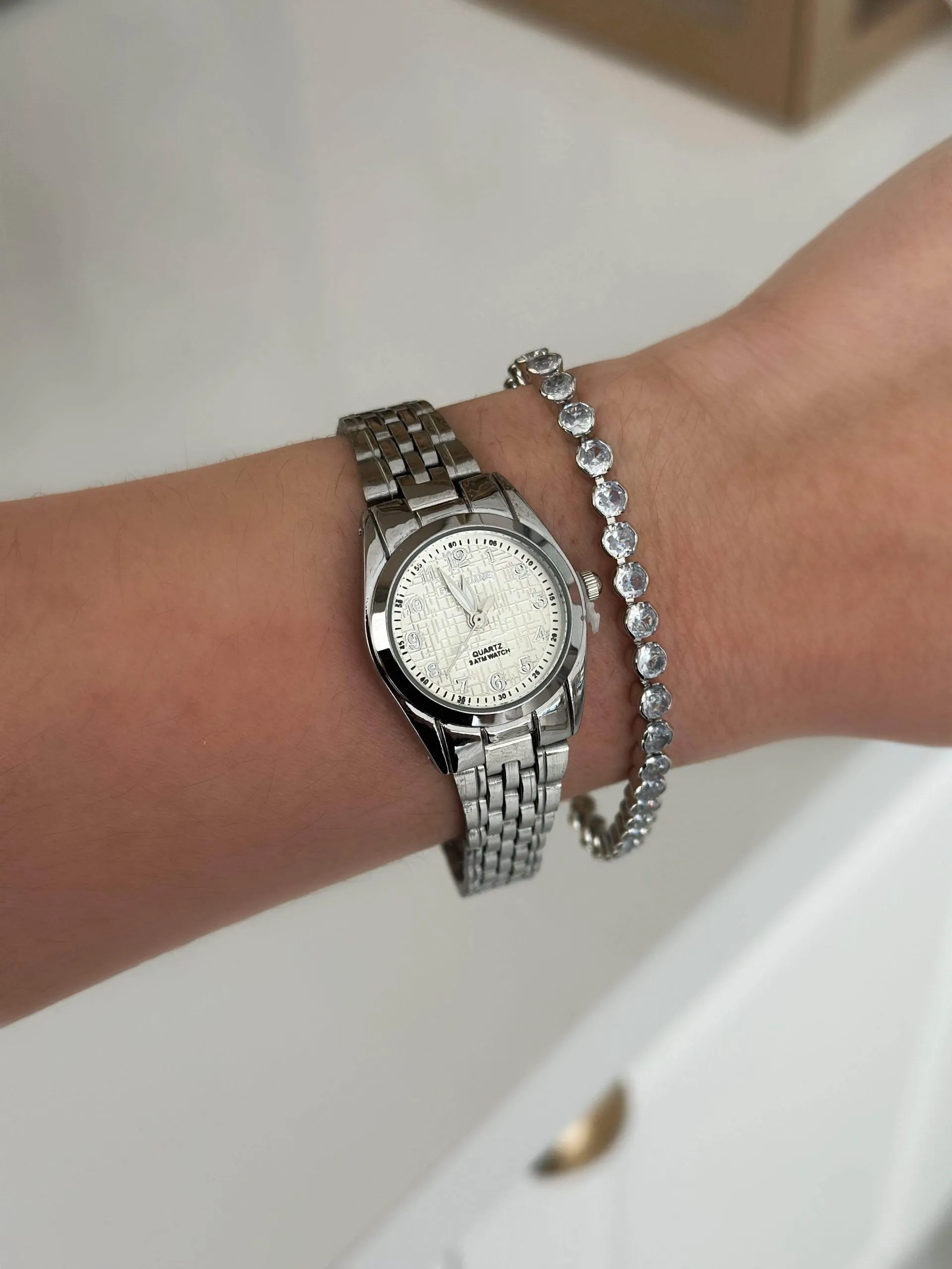 Relógio Prateado com Fundo Detalhado Branco