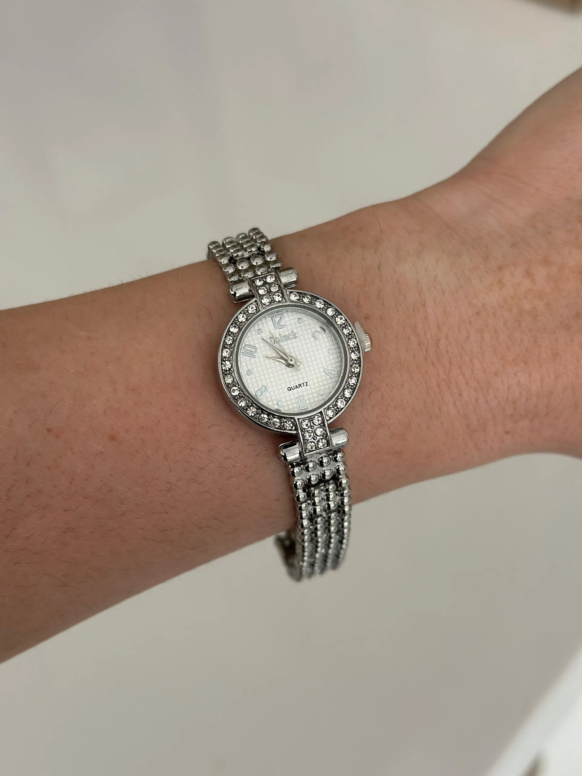 Relógio Prateado Cravejado com Fundo Branco